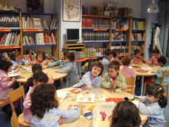 El alumnado de 4 años leyendo cuentos en la biblioteca